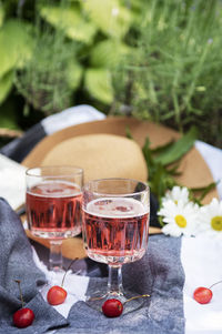 Picnic outdoors in lavender fields. rose wine in a glass, cherries and straw hat on blanket