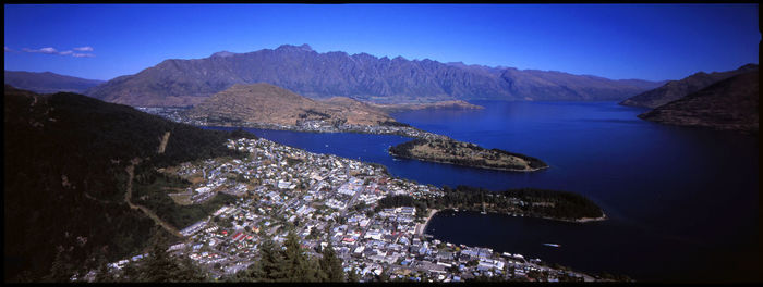 Panoramic view of lake and mountains against blue sky