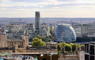 Buildings in city against cloudy sky