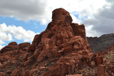 Low angle view of rock formation against cloudy sky
