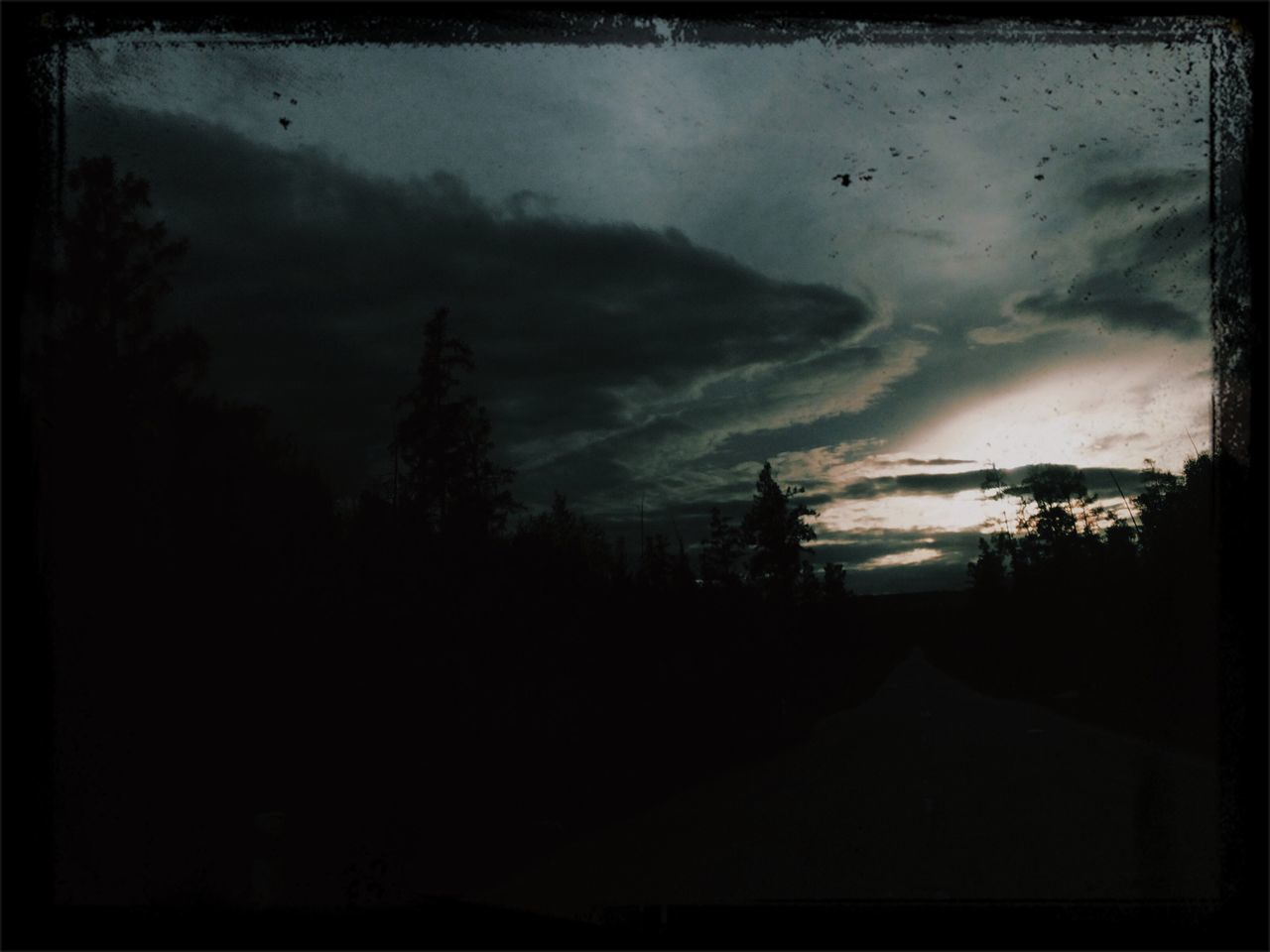 sky, transfer print, silhouette, cloud - sky, tree, auto post production filter, cloudy, weather, sunset, dusk, road, overcast, tranquility, nature, scenics, dark, tranquil scene, cloud, beauty in nature, storm cloud