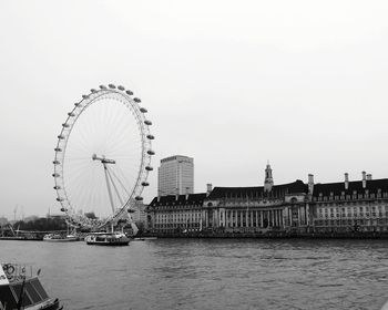 Ferris wheel in city against clear sky