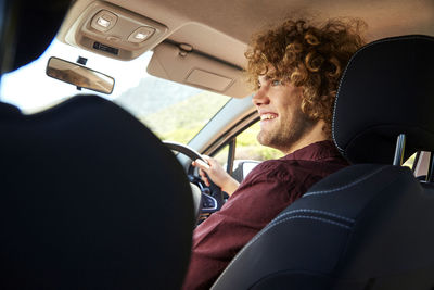 Rear view of man sitting in car