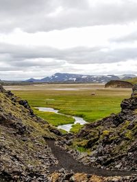 Scenic view of landscape against cloudy sky