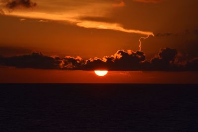 Scenic view of sea against dramatic sky during sunset