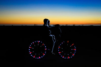 Close-up of silhouette people on beach against sky during sunset