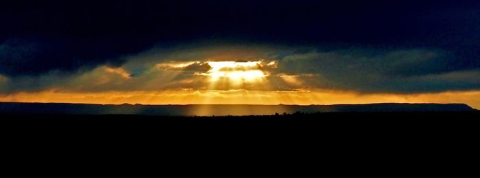 Silhouette of landscape against cloudy sky