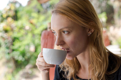 Woman drinking coffee outdoors