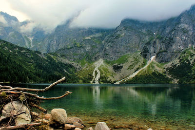 Scenic view of lake by mountains against sky