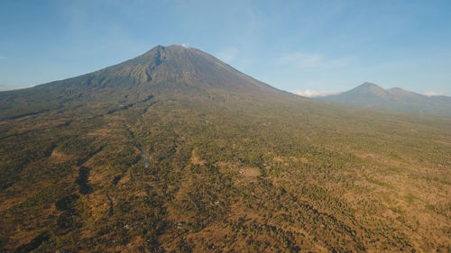 Aerial view of volcano mount agung with smoke billowing out at sunrise, bali, indonesia. 