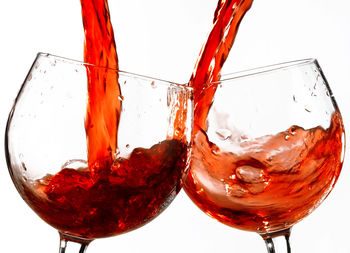 Close-up of red wine in glass against white background