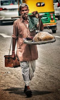 Full length of man holding ice cream standing on street