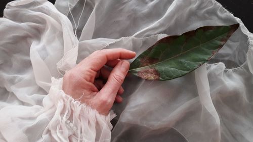 High angle view of woman holding hands on bed