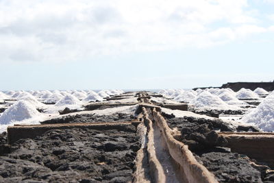 Close-up of  saltwork on land against sky