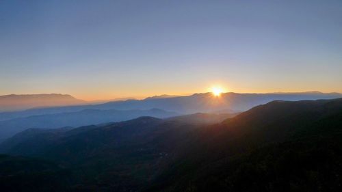 Scenic view of mountains against clear sky during sunset