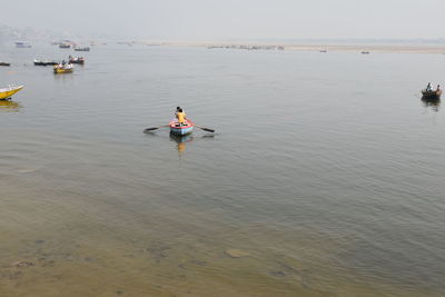 Rear view of man on sea against sky