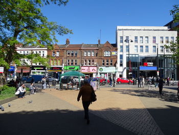 People on street against buildings in city