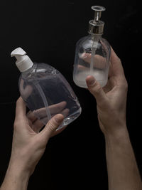 Midsection of person holding glass bottle