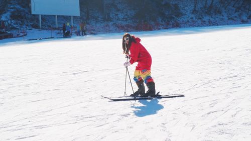 Full length of woman skiing on snow