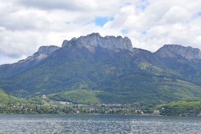 Scenic view of lake by mountains against sky