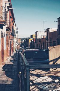 Street amidst buildings in city against clear sky