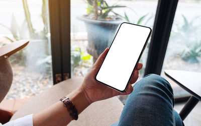 Cropped hands of woman using mobile phone