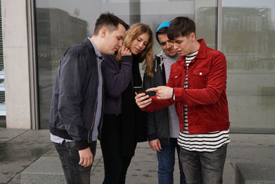 Full length of young man holding smart phone