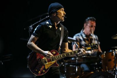 People playing guitar at music concert