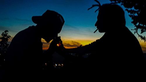 Portrait of silhouette people sitting against sky during sunset