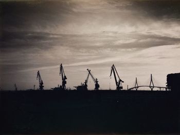 Silhouette of electricity pylon against sky during sunset