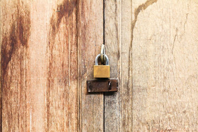 Close-up of padlock on wooden door