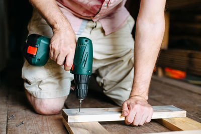 Work with a screwdriver. sewing together wooden block with a screw