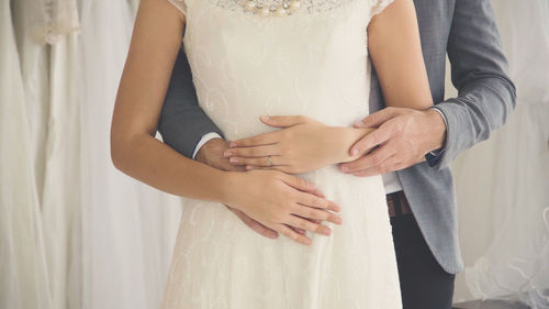 Midsection of couple holding hands