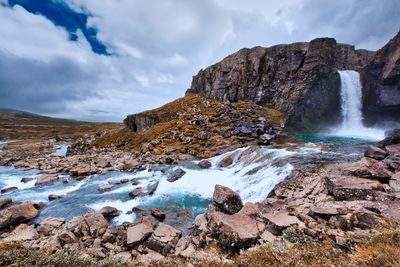 Scenic view of waterfall against sky