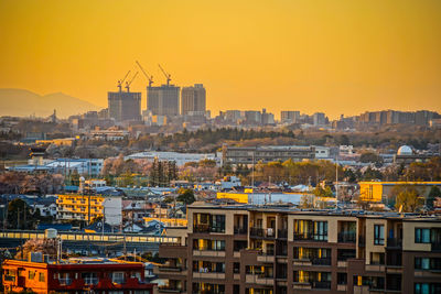 Buildings in city against orange sky