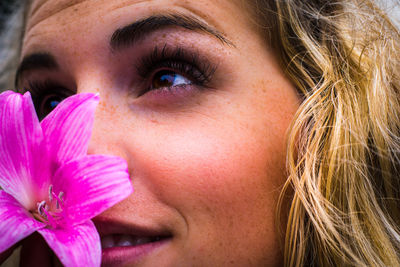 Close-up of young woman with pink amaryllis