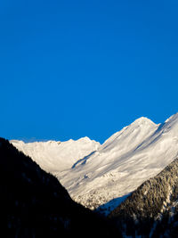 Scenic view of snowcapped mountains against clear blue sky