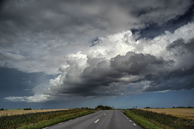 Road amidst field against sky