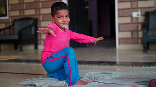  little indian boy doing yoga exercise and watching instructions on tv.. worldwide yoga day concept.
