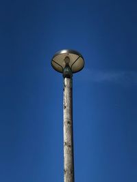 Low angle view of street light against blue sky