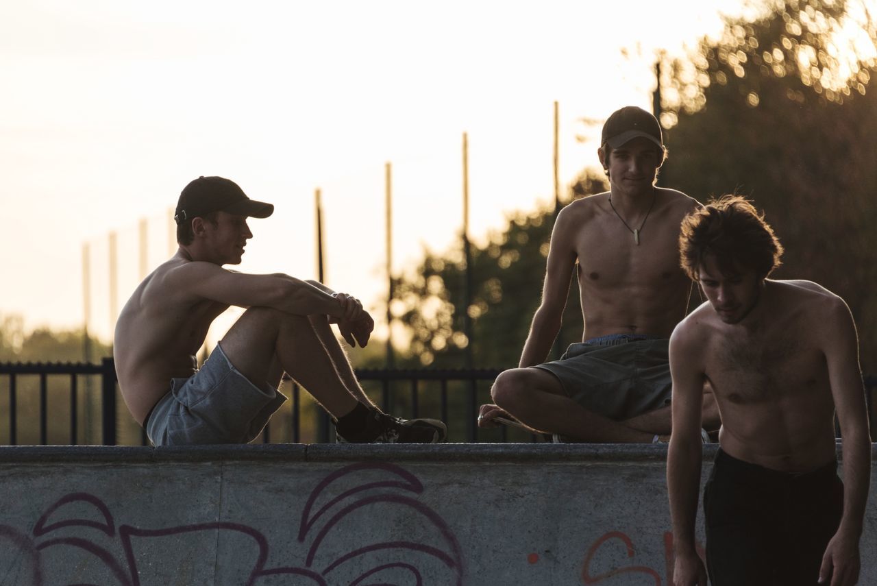 YOUNG MAN SITTING OUTDOORS