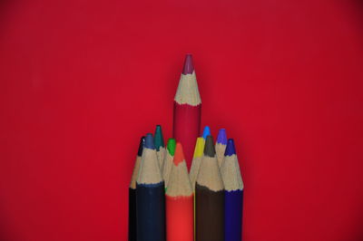 Close-up of colored pencils against red background