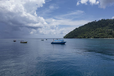 Boats sailing on sea against sky