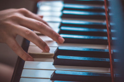 Close-up of hand playing piano