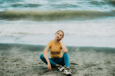 Portrait of young woman sitting on beach