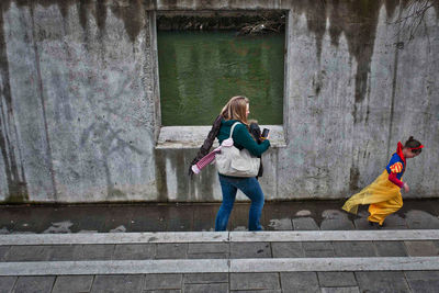 Rear view of friends standing against wall