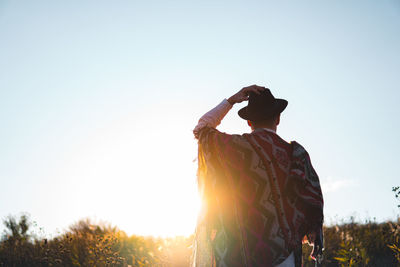 Rear view of woman standing against clear sky