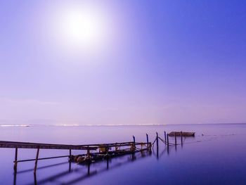 Pier over sea against sky during sunset