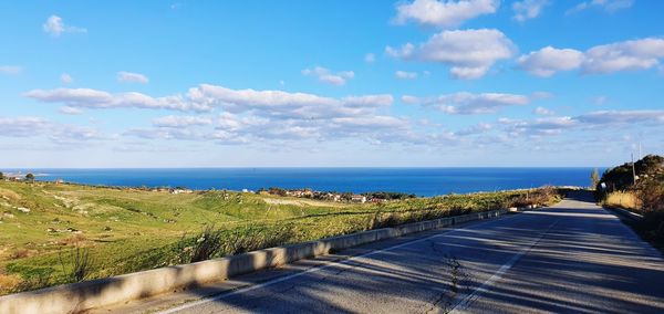 Road by sea against sky