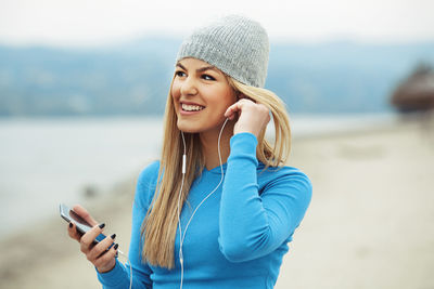 Smiling young woman using smart phone